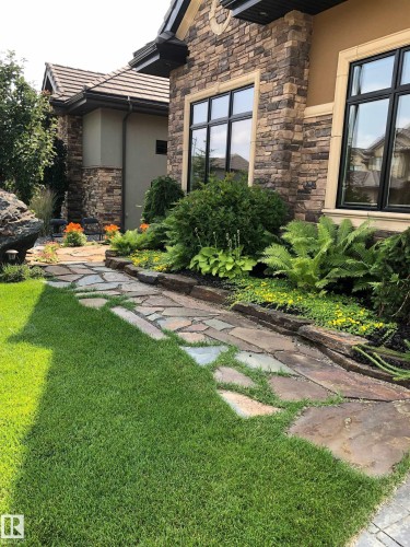 Stone and stucco exterior featuring black-framed windows with light trim - 3048 Watson Landing, Edmonton, AB - Outdoor