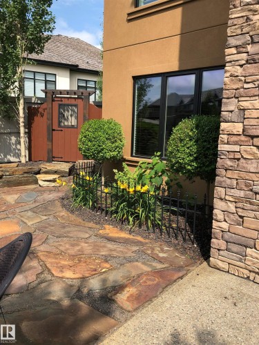 Stone patio and walkway with a decorative garden bed - 3048 Watson Landing, Edmonton, AB - Outdoor