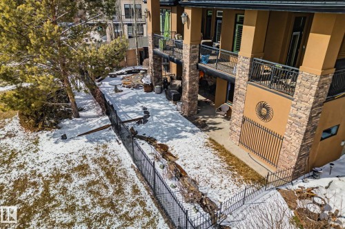 Terraced exterior featuring multiple balconies with black metal railings, stone veneer accents, stucco siding. - 3048 Watson Landing, Edmonton, AB - Outdoor