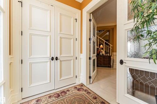 The property features white paneled double doors with black hardware, and an entryway with a decorative rug - 3048 Watson Landing, Edmonton, AB - Indoor Photo Showing Other Room