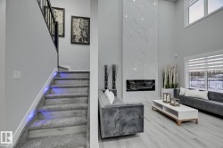 Two-story living area with a floor-to-ceiling marble-patterned fireplace - 