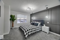 Accent wall featuring decorative molding, modern pendant lighting, and a fabric upholstered headboard - 