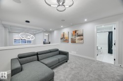 Carpeted open-concept bonus room featuring recessed lighting, a modern ceiling light fixture, and an open doorway revealing a full bathroom with a tub and shower combination - 