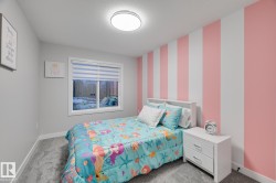 Bedroom featuring a full-size window with blinds, a prominent striped accent wall, light gray walls, plush carpeting, and a flush-mount ceiling light - 