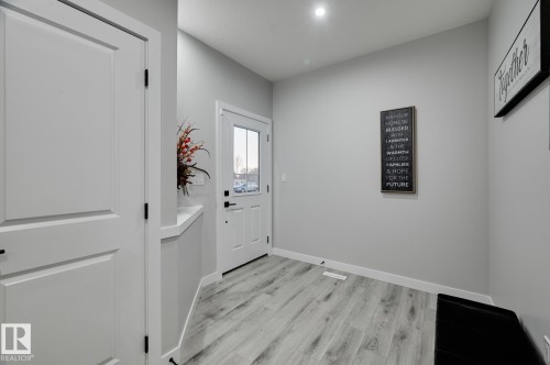 Entryway featuring wood-finish flooring, white trim, and a white paneled door - 1774 Crossbill Loop, Edmonton, AB - Indoor Photo Showing Other Room