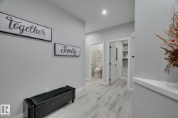 Hallway featuring light wood-finish flooring, recessed ceiling lighting, and crisp white baseboards - 