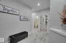 Hallway featuring light wood-finish flooring, recessed ceiling lighting, and crisp white baseboards - 1774 Crossbill Loop, Edmonton, AB  - Indoor Photo Showing Other Room 