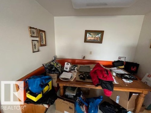 The property features an interior space with light-colored walls and a wood dining table - 11003 144 Street, Edmonton, AB - Indoor