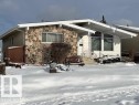 The property features a stone facade and white siding, with a front entrance accessible via steps with a metal railing - 11003 144 Street, Edmonton, AB  - Outdoor 