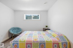 Bedroom featuring a window with a white frame, wood-finish flooring, and white walls - 