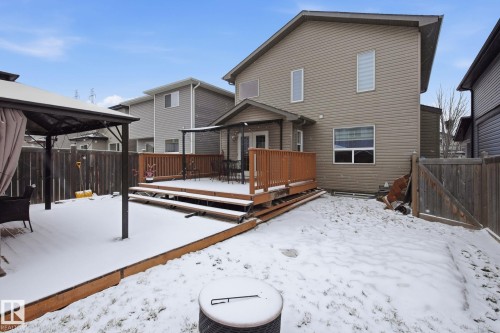 Expansive backyard featuring a multi-level wood deck, wood privacy fencing, and a separate patio area with a built-in gazebo frame - 3016 24 Ave, Edmonton, AB - Outdoor With Exterior