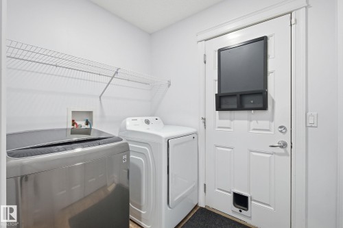 Dedicated laundry area featuring a wire shelving unit, a utility hookup, and a paneled exterior door with a pet access opening - 3016 24 Ave, Edmonton, AB - Indoor Photo Showing Laundry Room