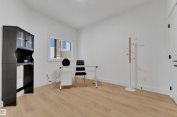 Bright room featuring light wood-finish flooring, white walls, and a white trim - 