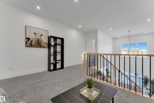 Upper-level landing featuring light-toned wood and black metal balusters, recessed lighting, and expansive windows - 247 Linden Loop, Leduc, AB - Indoor Photo Showing Other Room