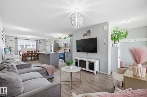 This open-concept living area features light-toned flooring, recessed lighting, and a modern light fixture - 4636 175 Ave, Edmonton, AB - Indoor Photo Showing Living Room