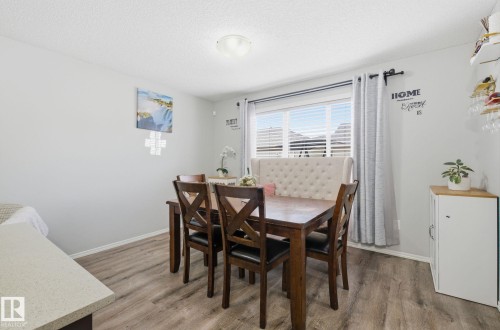 Dining area featuring light wood tone flooring, a window with horizontal blinds, and a ceiling light fixture - 4636 175 Ave, Edmonton, AB - Indoor Photo Showing Dining Room