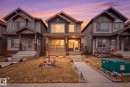 This property features a welcoming front porch with decorative railings, complemented by exterior siding and stone accents - 4636 175 Ave, Edmonton, AB  - Outdoor With Facade 