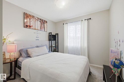 Bedroom featuring light gray walls, a window with white curtains, and carpeted flooring - 4636 175 Ave, Edmonton, AB - Indoor Photo Showing Bedroom