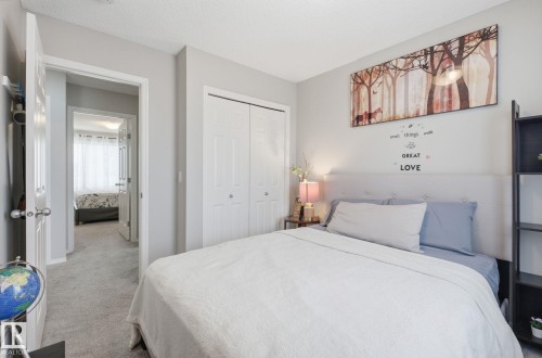 The bedroom features light gray walls, light gray carpet, and white bi-fold closet doors - 4636 175 Ave, Edmonton, AB - Indoor Photo Showing Bedroom