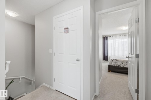 Well-maintained interior hallway with light gray walls and a white door - 4636 175 Ave, Edmonton, AB - Indoor Photo Showing Other Room