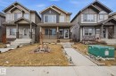 The property features a charming exterior with a covered front porch, stone accents, and a well-maintained front yard - 4636 175 Ave, Edmonton, AB  - Outdoor With Facade 
