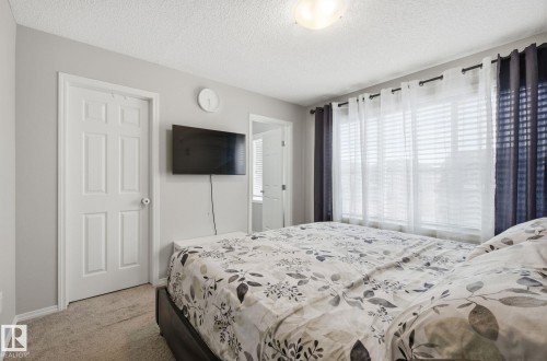 This room features light gray walls, a window with blinds and sheer curtains, and a ceiling light fixture - 4636 175 Ave, Edmonton, AB - Indoor Photo Showing Bedroom