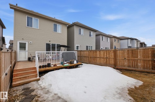 The property features a wooden deck with white railings, accessible via a glass-paneled door and a sliding glass door - 4636 175 Ave, Edmonton, AB - Outdoor With Exterior