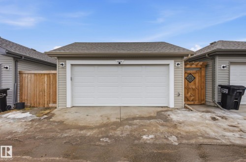 The property features a garage with a white overhead door and light-colored siding - 4636 175 Ave, Edmonton, AB - Outdoor With Exterior