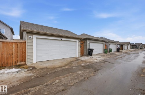 The property includes a detached garage with a white garage door, light-colored siding, and a brown shingled roof - 4636 175 Ave, Edmonton, AB - Outdoor