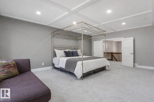 Spacious room featuring coffered ceilings with recessed lighting, light-toned carpeting, and a neutral wall palette - 8927 120 Street, Edmonton, AB - Indoor Photo Showing Bedroom