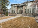 Contemporary exterior featuring a double-door entry, stone veneer accents, stucco siding, a covered porch, and multiple windows - 8927 120 Street, Edmonton, AB  - Outdoor 