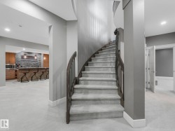 Curved staircase with wood-finish handrail and carpeted steps - 