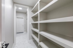 Built-in shelving providing ample storage, complemented by a white paneled door and marble-look tile flooring - 