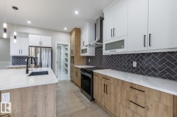 Modern kitchen featuring two-tone cabinetry with white upper and wood-finish lower cabinets - 