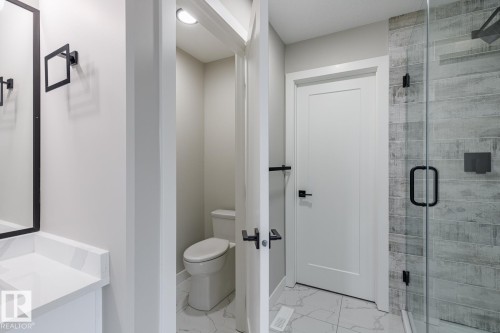 Bathroom with a glass-enclosed shower featuring wood-finish tile - 48 Chartres Close, St. Albert, AB - Indoor Photo Showing Bathroom