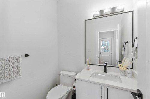 White vanity with integrated rectangular sink, matte black faucet, and white countertop - 124 28 Street, Edmonton, AB 