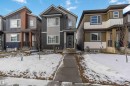 Modern split-level exterior featuring multiple facade materials including vertical siding and board and batten - 124 28 Street, Edmonton, AB 