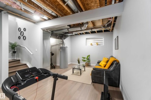 Finished lower level offering light wood-finish flooring and a partial exposed ceiling - 124 28 Street, Edmonton, AB 