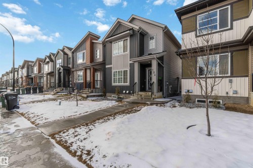 Contemporary exterior featuring mixed-material siding, a covered front entry, and a prominent front window with horizontal blinds - 124 28 Street, Edmonton, AB 