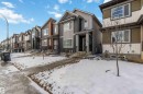 Contemporary exterior featuring mixed-material siding, a covered front entry, and a prominent front window with horizontal blinds - 124 28 Street, Edmonton, AB 