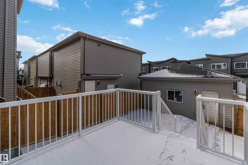 Rear deck with white metal railings and wooden privacy fencing - 124 28 Street, Edmonton, AB 