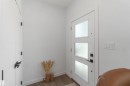 Entryway featuring a white door with three frosted glass panels, a second white interior door, and light wood-finish flooring - 124 28 Street, Edmonton, AB 