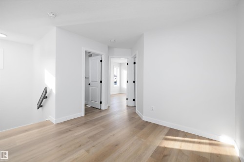 Bright interior space featuring light wood-finish flooring, crisp white walls, and contemporary baseboards - 954 Elderberry Landing, Edmonton, AB - Indoor Photo Showing Other Room