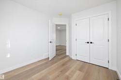 Room featuring light wood-finish flooring, white walls, and white baseboards - 