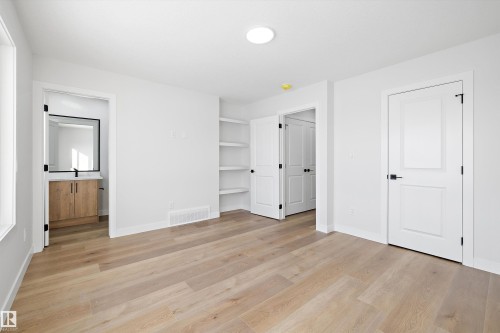 Spacious room featuring wood-finish flooring and bright white walls - 954 Elderberry Landing, Edmonton, AB - Indoor Photo Showing Other Room