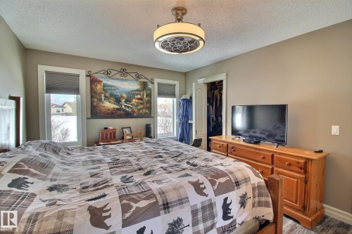 Bedroom with two windows and a ceiling light fixture - 1212 Westerra Crescent, Stony Plain, AB - Indoor Photo Showing Bedroom