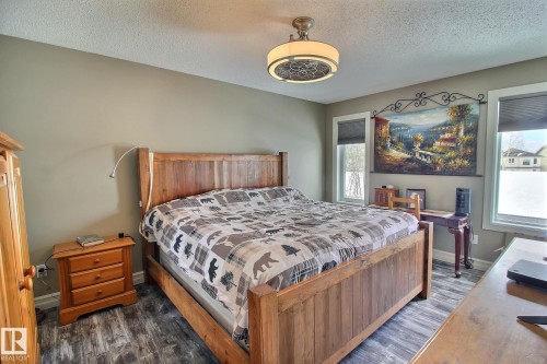 The property features a bedroom with durable flooring, two windows providing natural light, and a ceiling light fixture - 1212 Westerra Crescent, Stony Plain, AB - Indoor Photo Showing Bedroom