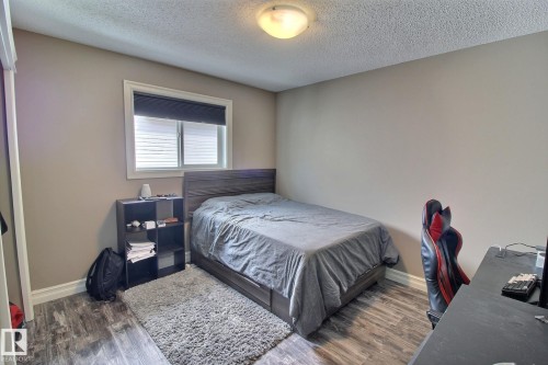 This room features neutral-toned walls, a window with blinds, and wood-style flooring - 1212 Westerra Crescent, Stony Plain, AB - Indoor Photo Showing Bedroom
