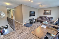 The property features wood-look flooring throughout the main areas, complemented by light-colored walls and white baseboards - 