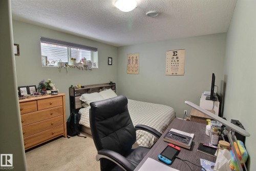 This room features light green walls and carpeted flooring, with a window providing natural light - 1212 Westerra Crescent, Stony Plain, AB - Indoor Photo Showing Bedroom